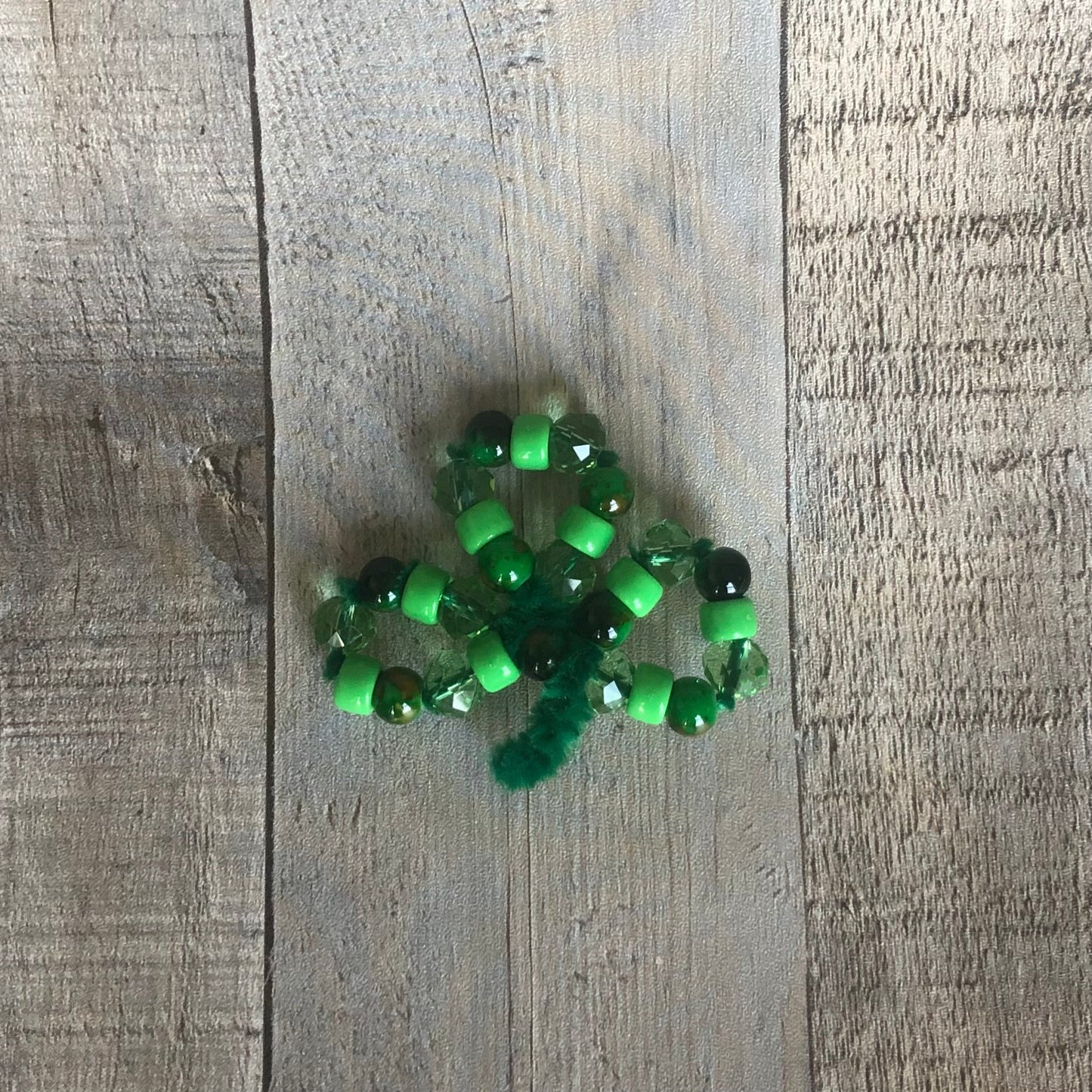 a beaded St. Patrick's Day shamrock pin. The craft kit is available on seniorlycreations.com.